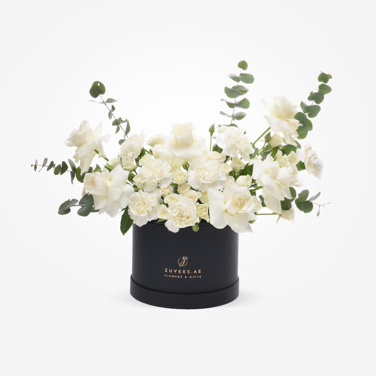 Elegant white roses and carnations with eucalyptus in a black Zuvees.AE gift box.